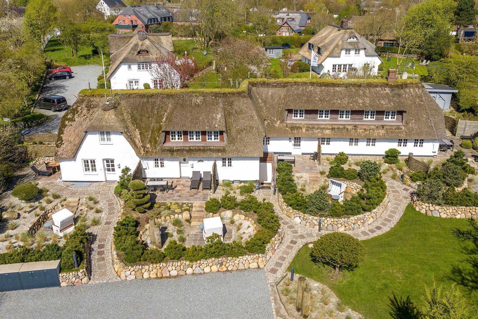 Traditionelles Haus mit Strohdach und gepflegtem Garten