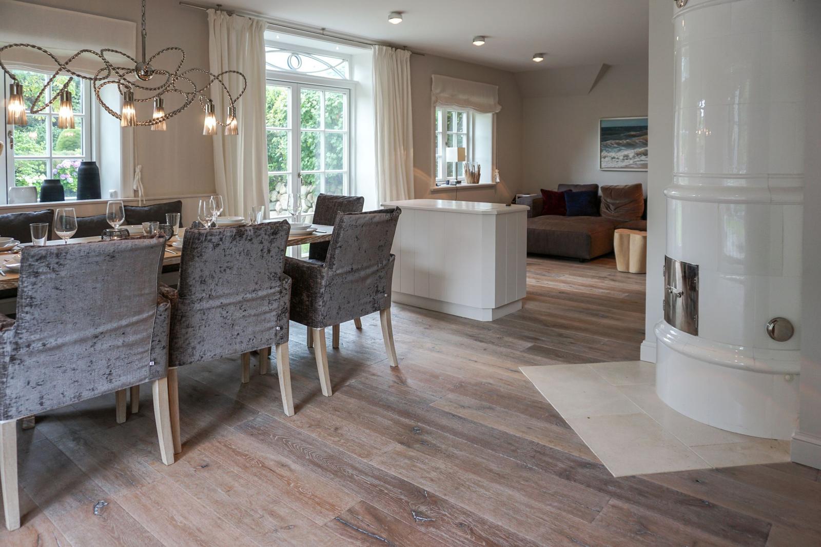 Dining room with table, chairs, and windows. Living area with sofa and fireplace.