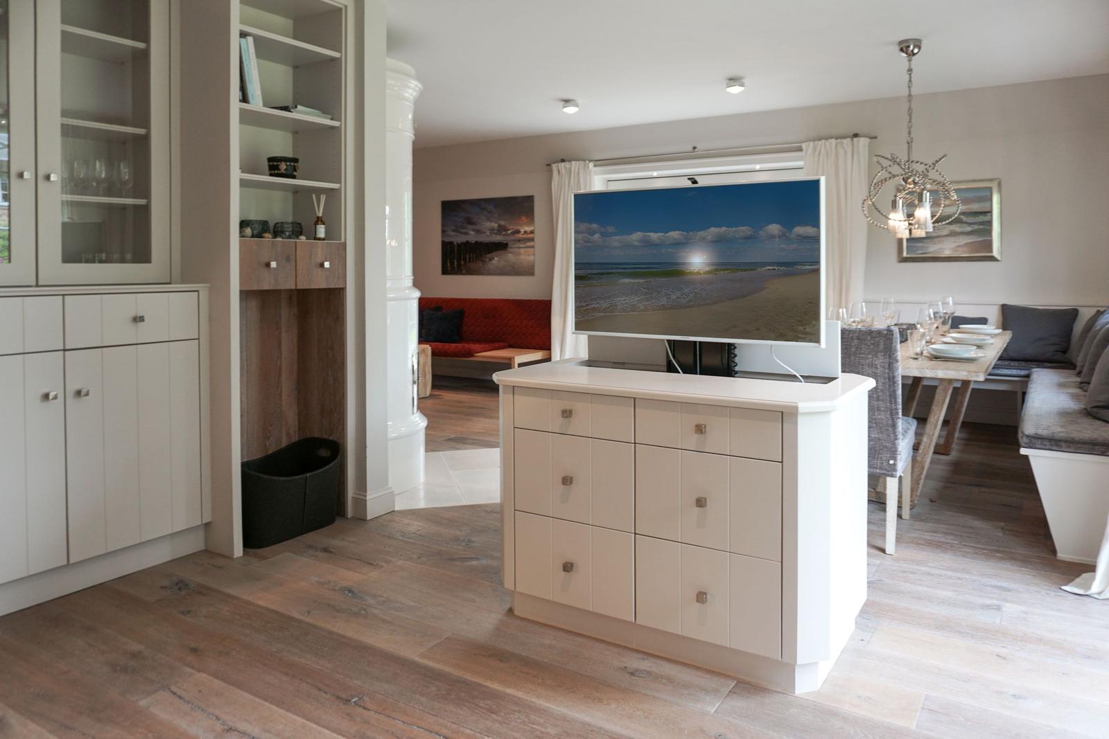 Living and dining area with TV, table, and sofa.
