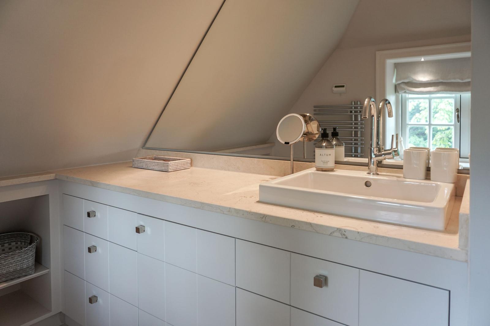 Bathroom with sink, mirror, and window