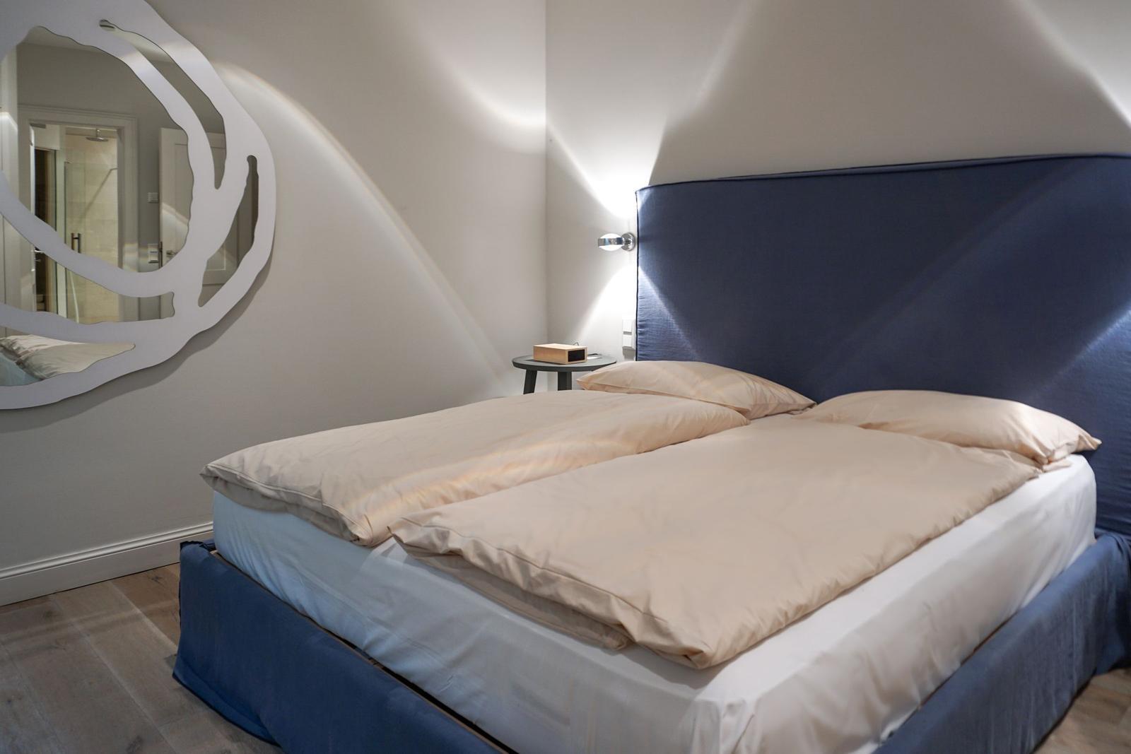 Bedroom with bed, headboard, and wall mirror