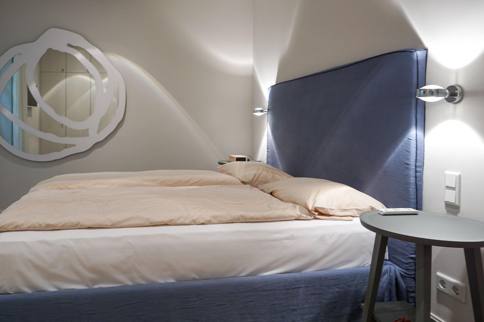 Bedroom with bed, headboard, and wall mirror.