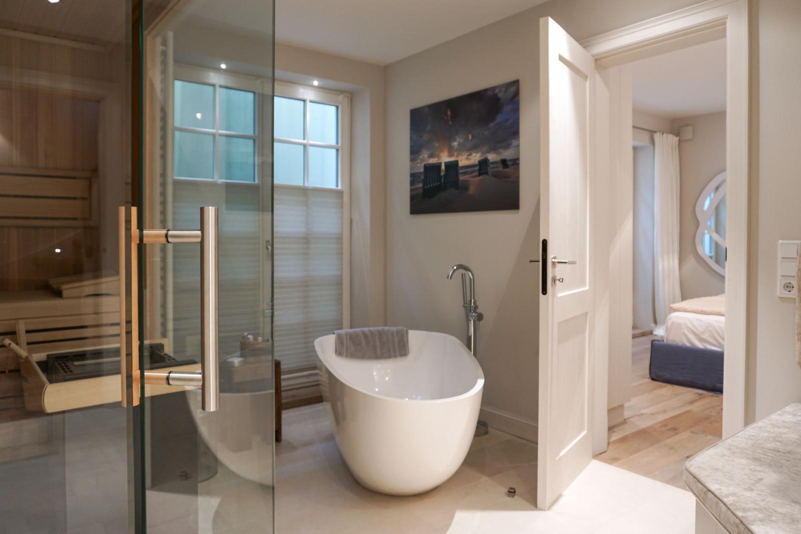 Bath with freestanding bathtub, sauna, and view into bedroom