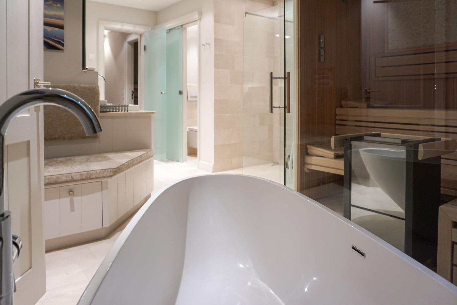 Bathroom with freestanding tub, shower, and sauna.