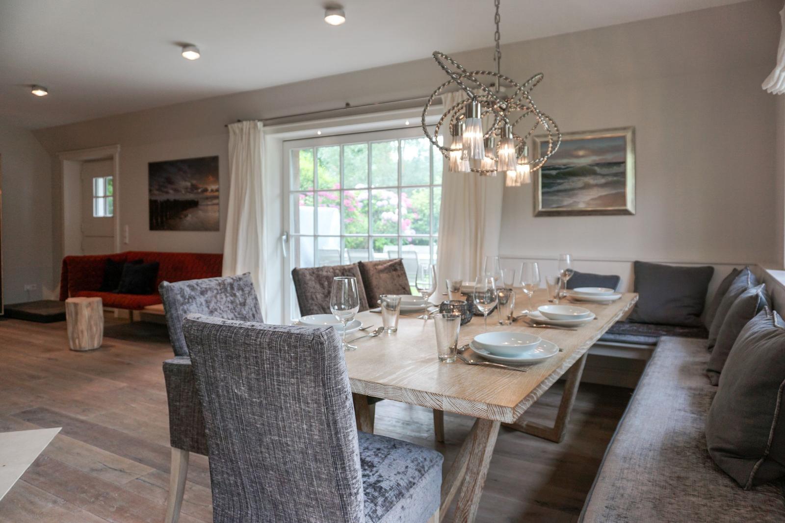 Dining area with long table, chairs, and window view