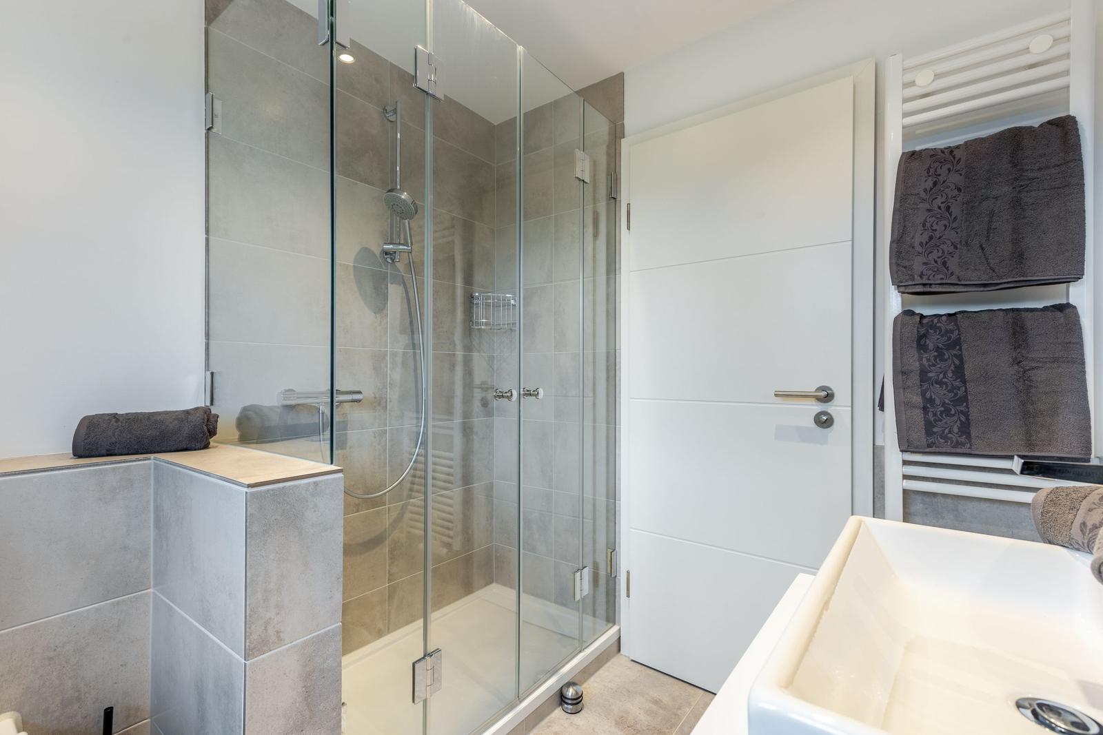 Bathroom with shower, sink, and towels.