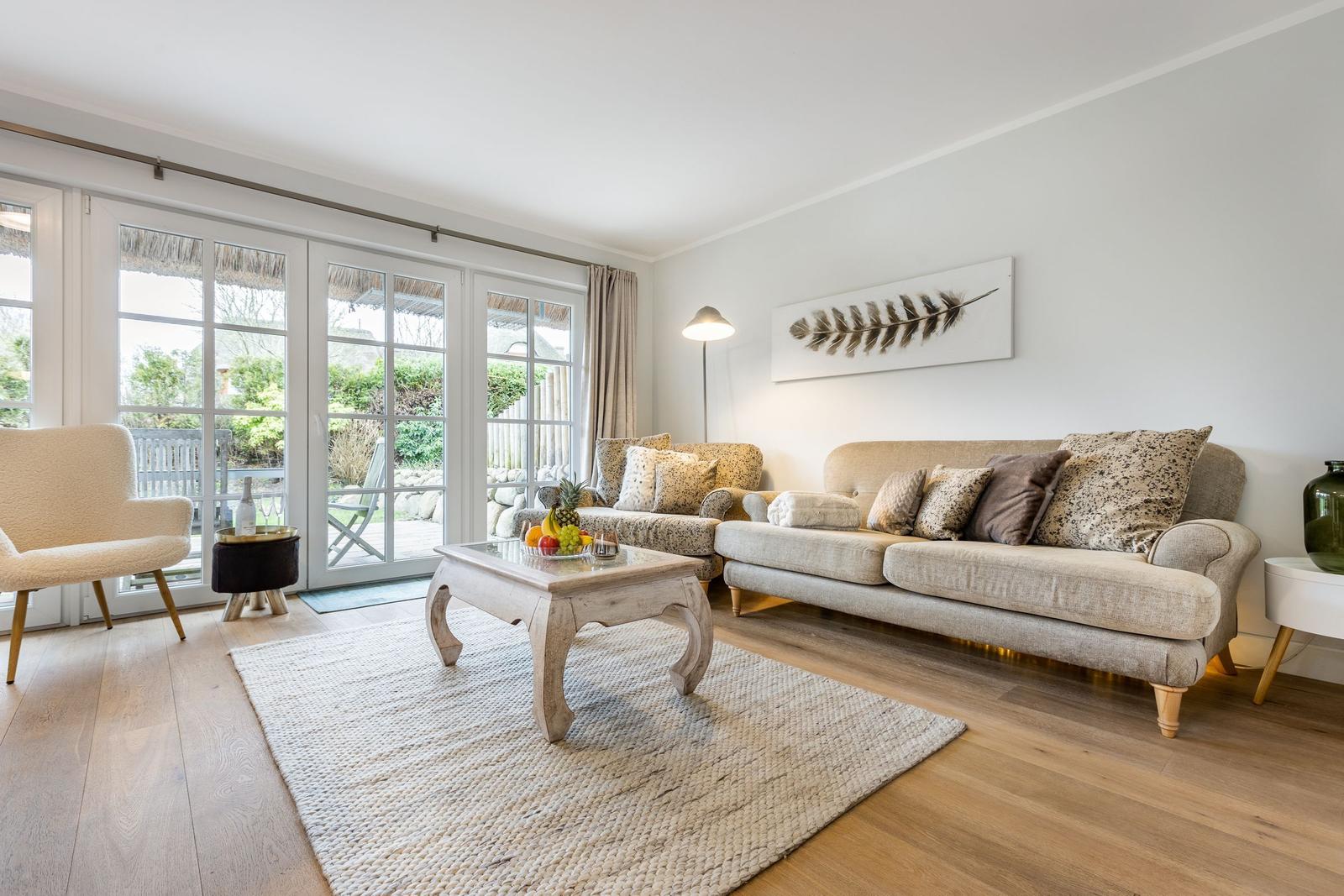 Living room with sofa, seating group, and glass doors to terrace.