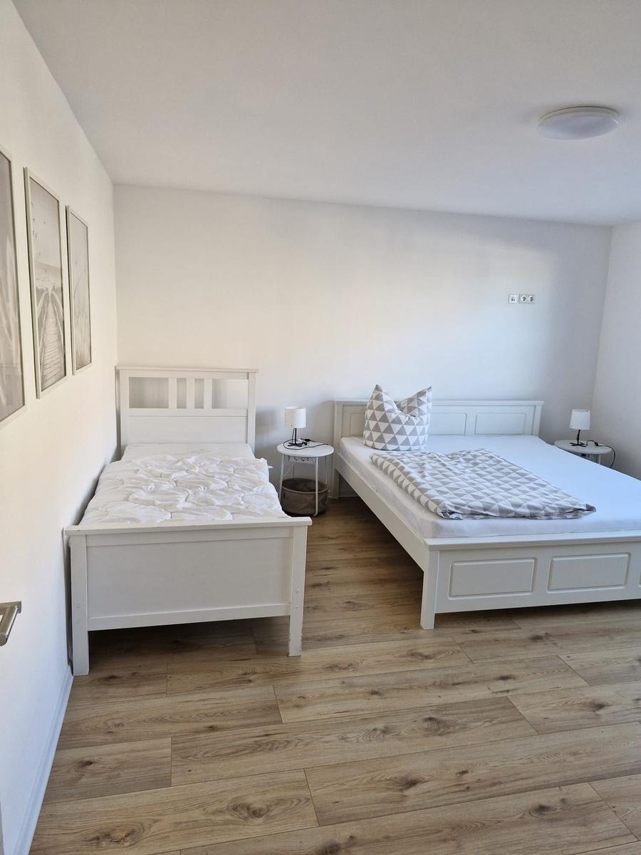 Schlafzimmer 1  mit einem großen Doppelbett und einem Einzelbett...
