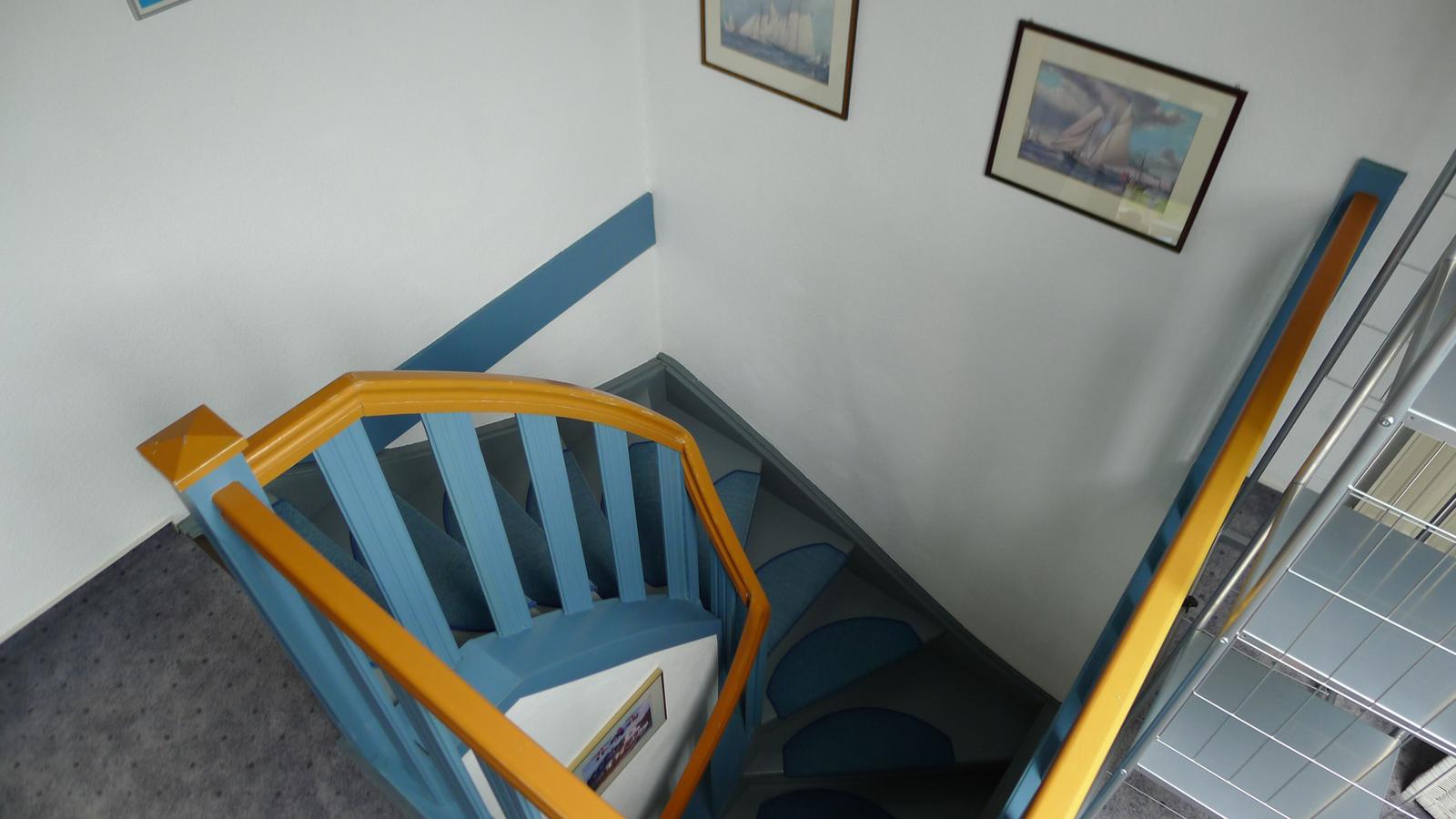 Treppe mit blauen Stufen und gelben Handläufen, Wandbilder mit Segelbooten