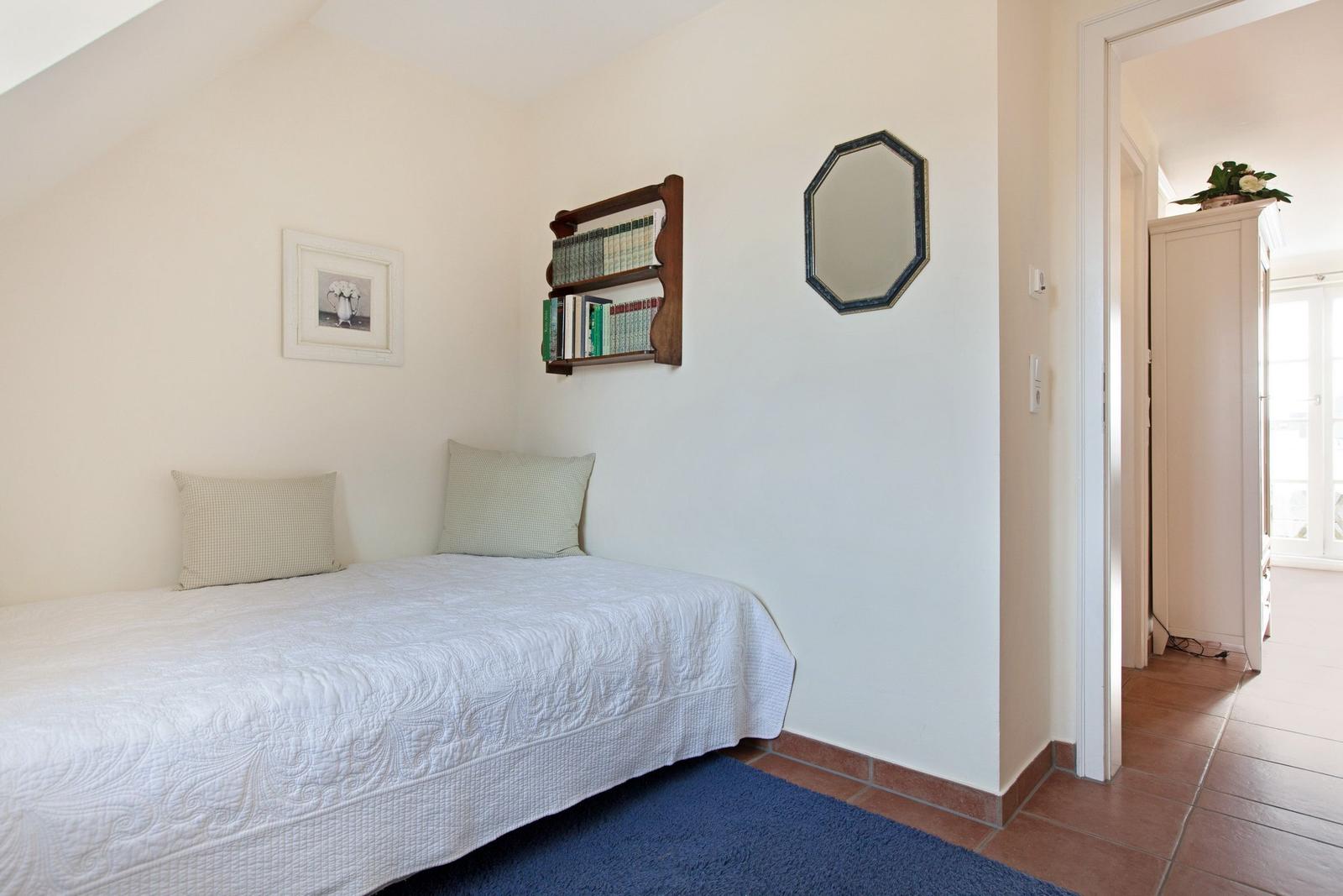Bedroom with bed, wall shelf, and mirror