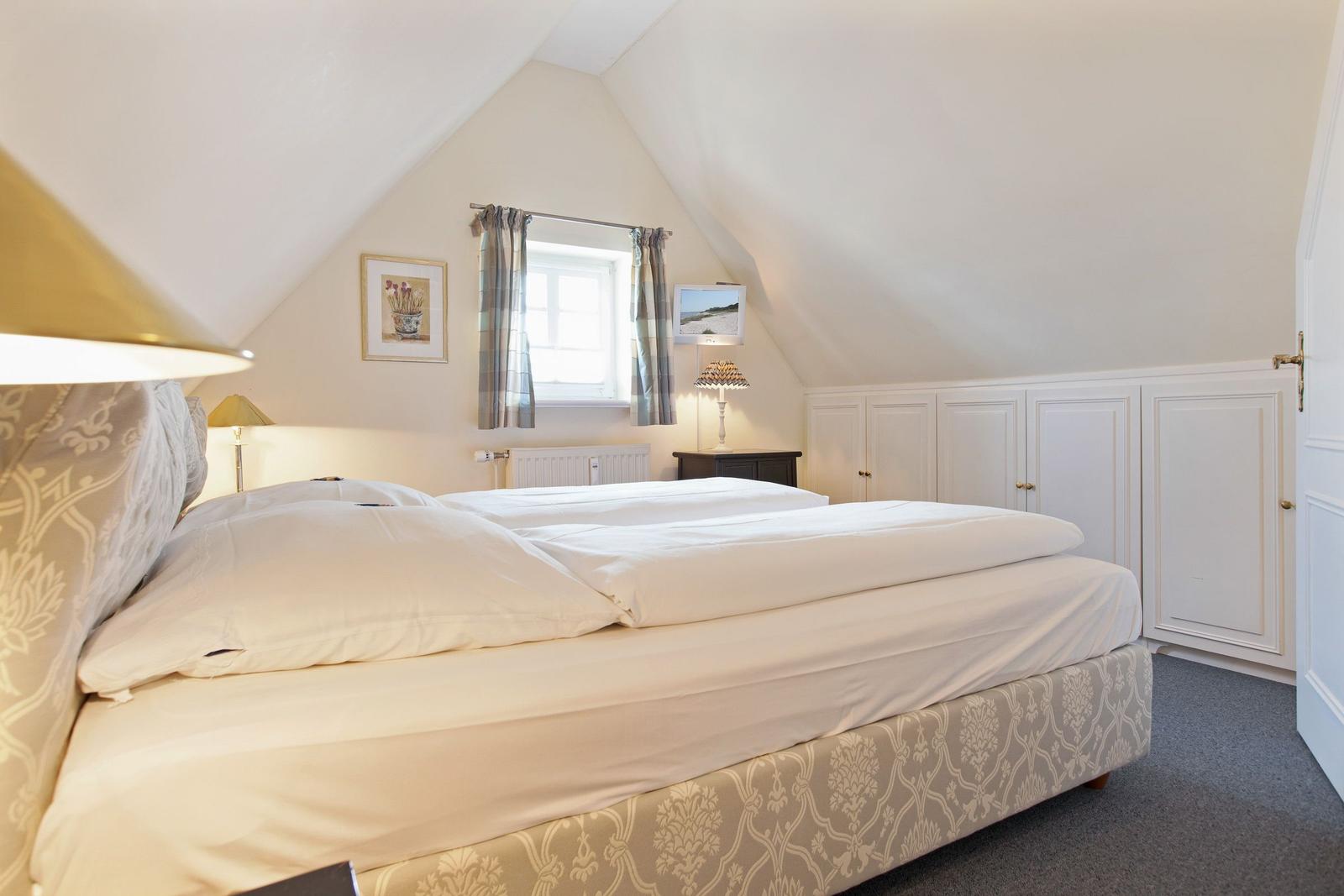 Bedroom with double bed, window, and wardrobe