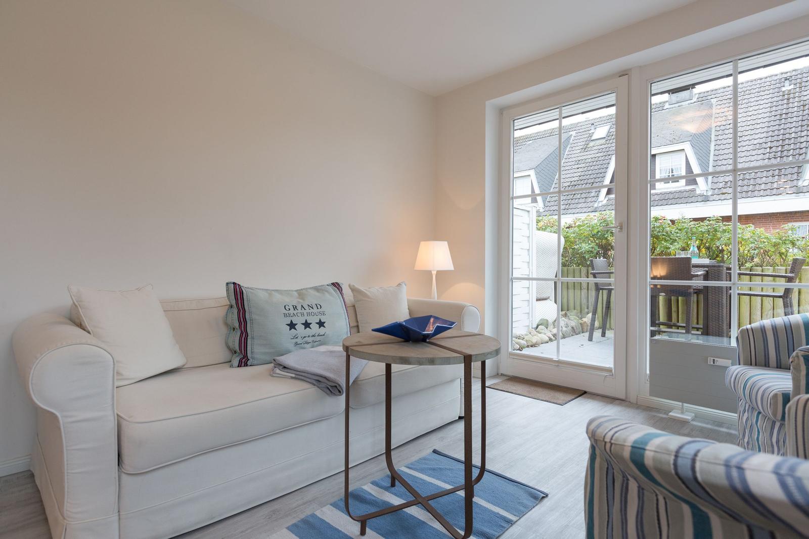 Wohnzimmer mit Sofa, Tisch und Blick auf Balkon