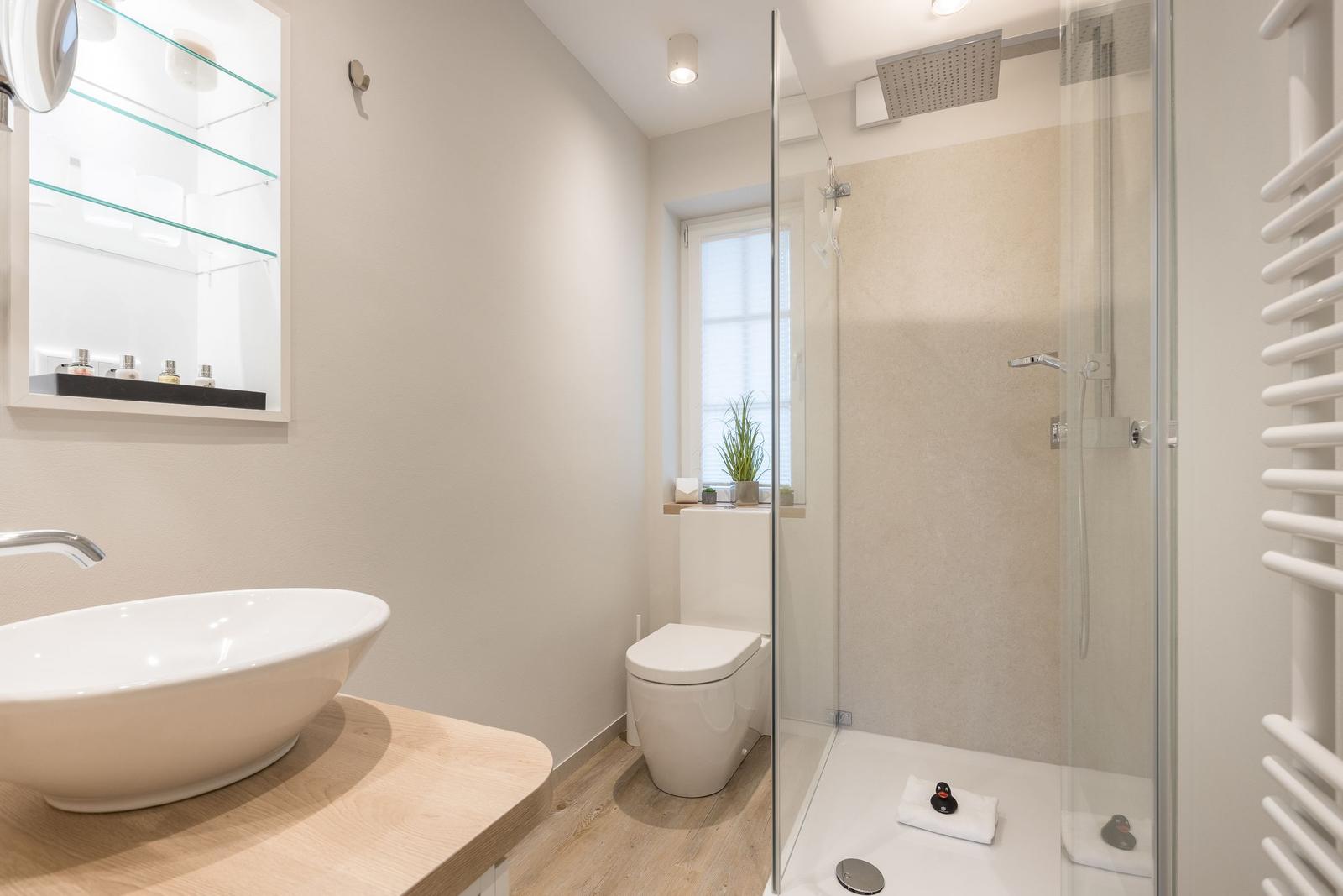 Badezimmer mit Dusche, Waschbecken und Toilette.
