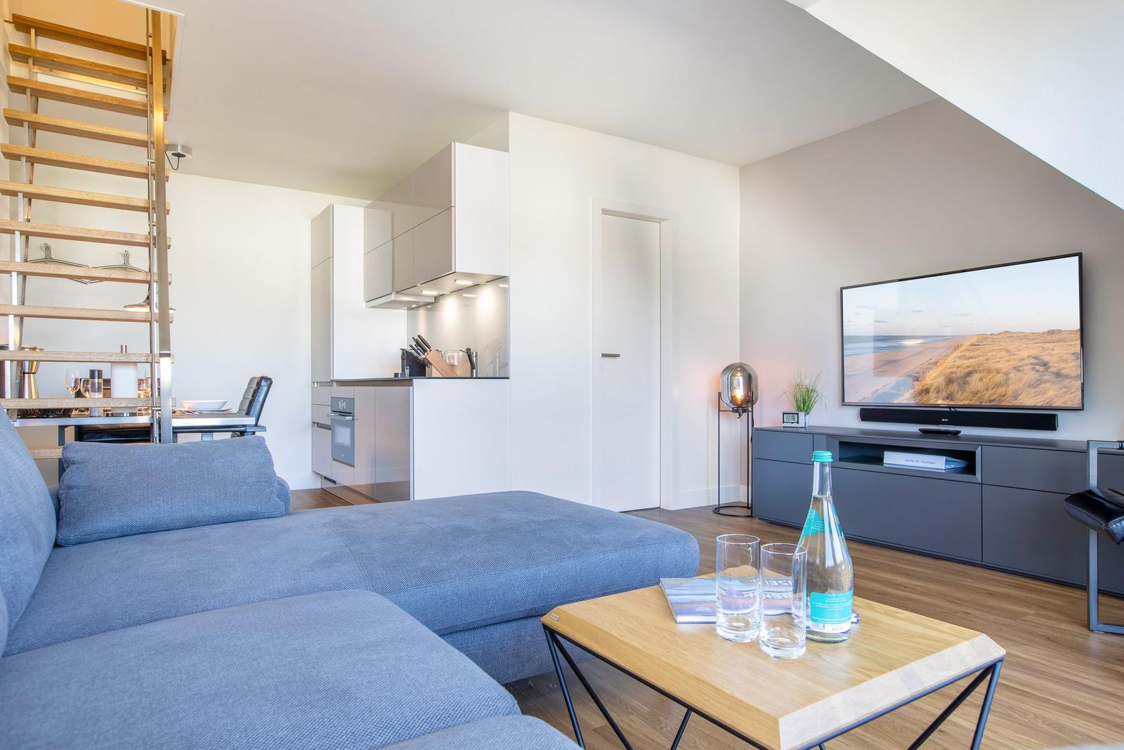 Living area with sofa, TV, and kitchen area