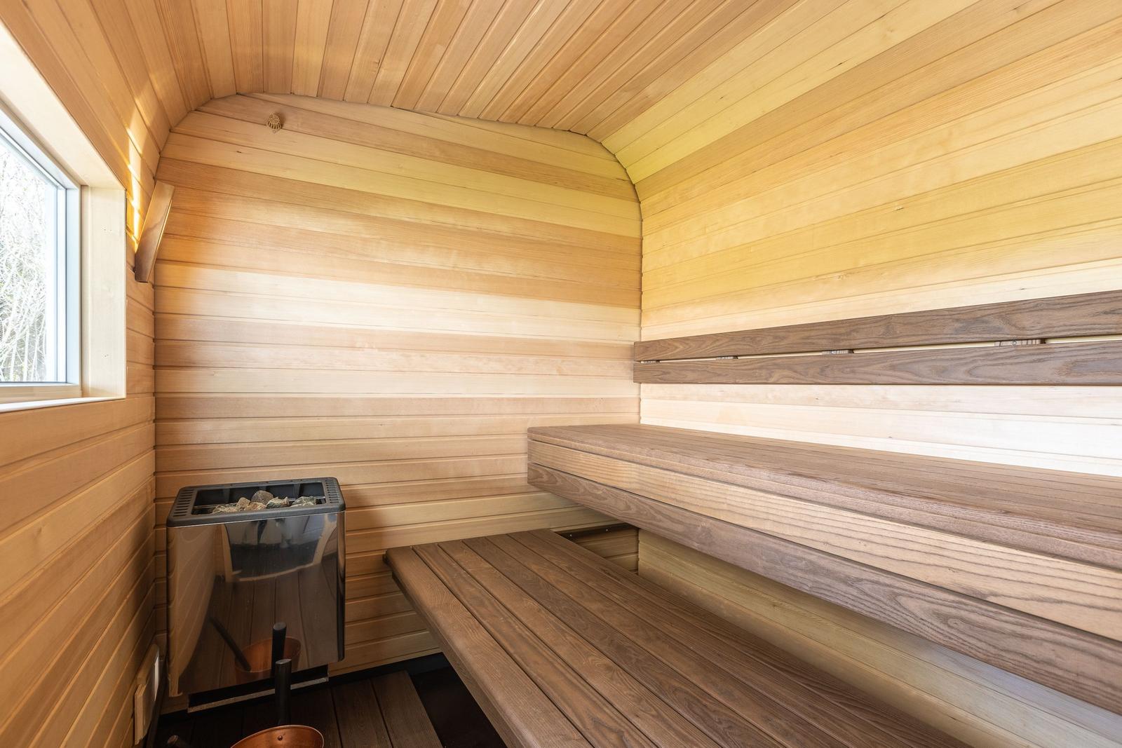 Sauna mit Holzbank und Ofen an der Wand