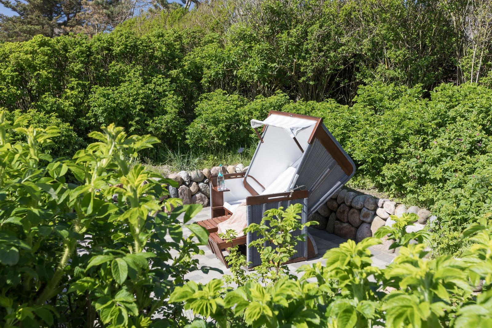 Liegende Hängematte mit Sonnenschutz in grüner Umgebung
