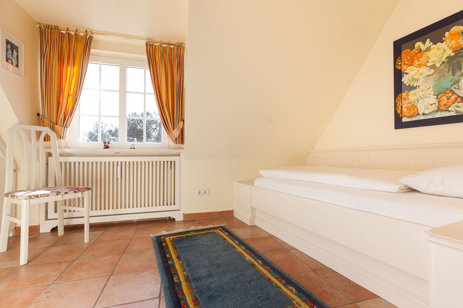 Bedroom with bed, chair, window, and rug