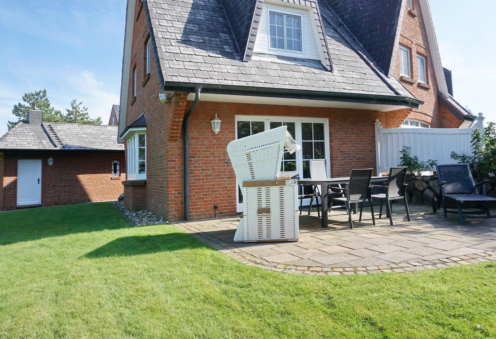 Red brick house with terrace, garden, and outdoor seating.