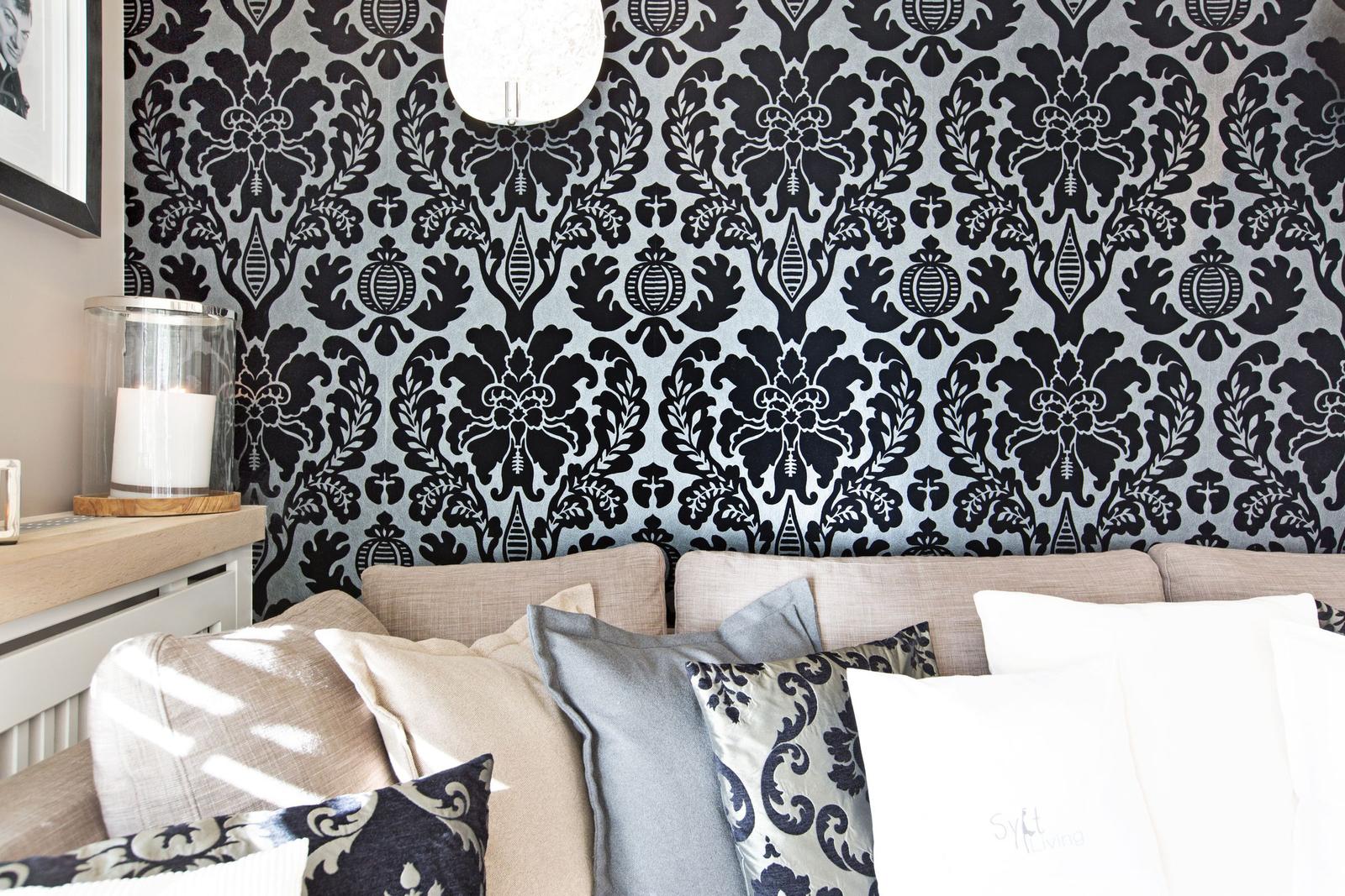 Sofa mit Kissen vor gemusterter Wand