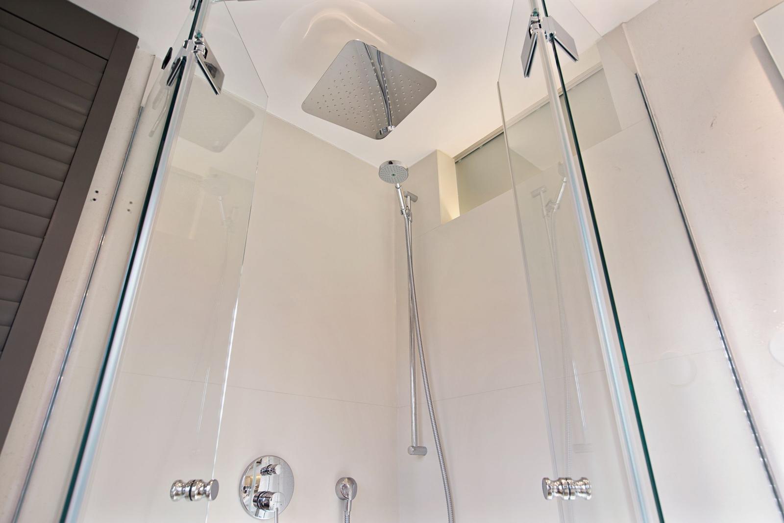 Dusche mit Glaswand und Duschbrause an der Decke
