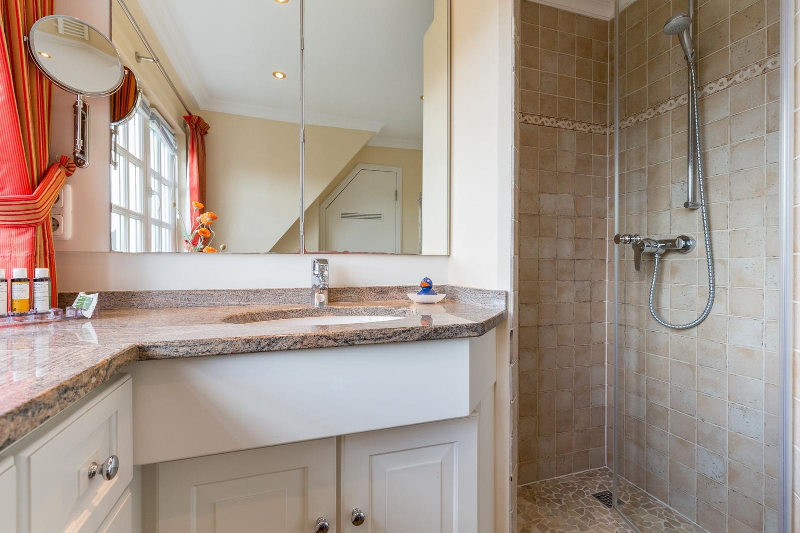 Bathroom with shower, sink, and mirror