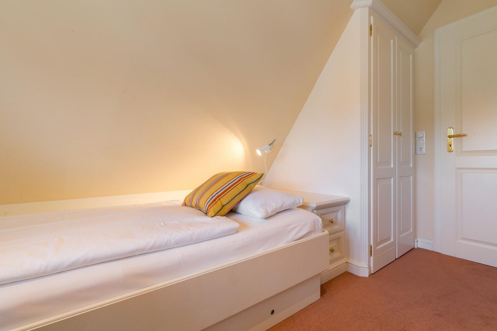 Bedroom with double bed, nightstand, and wardrobe.