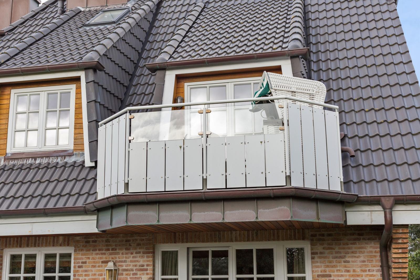 House with balcony, white railing, and wicker basket