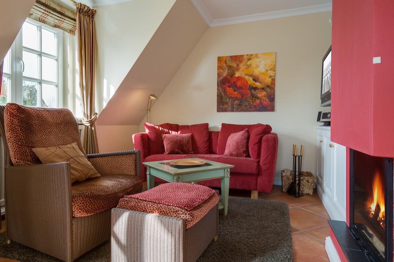 Living room with red sofa, fireplace, and wall art