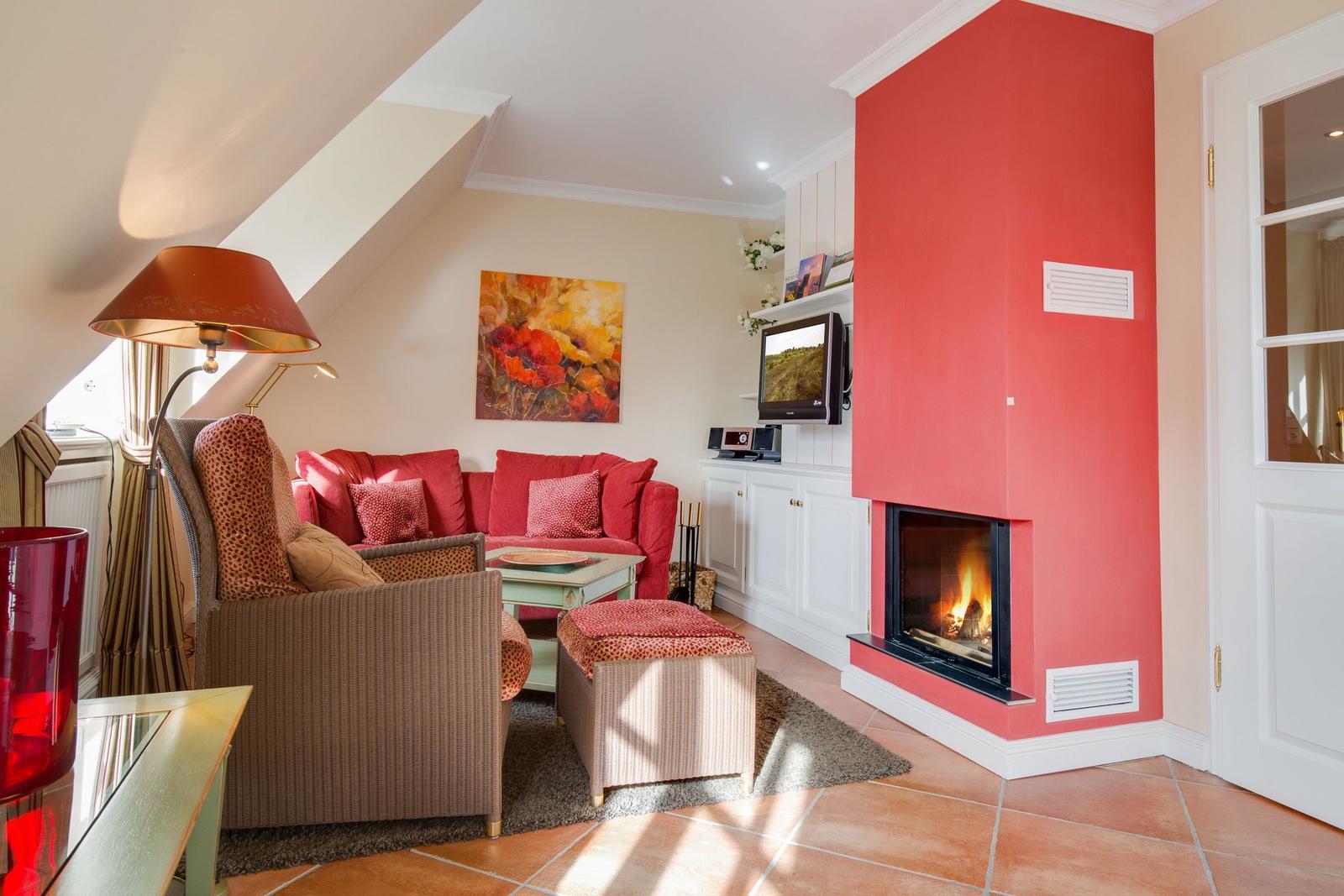 Living room with fireplace, sofa and armchair under sloped ceiling