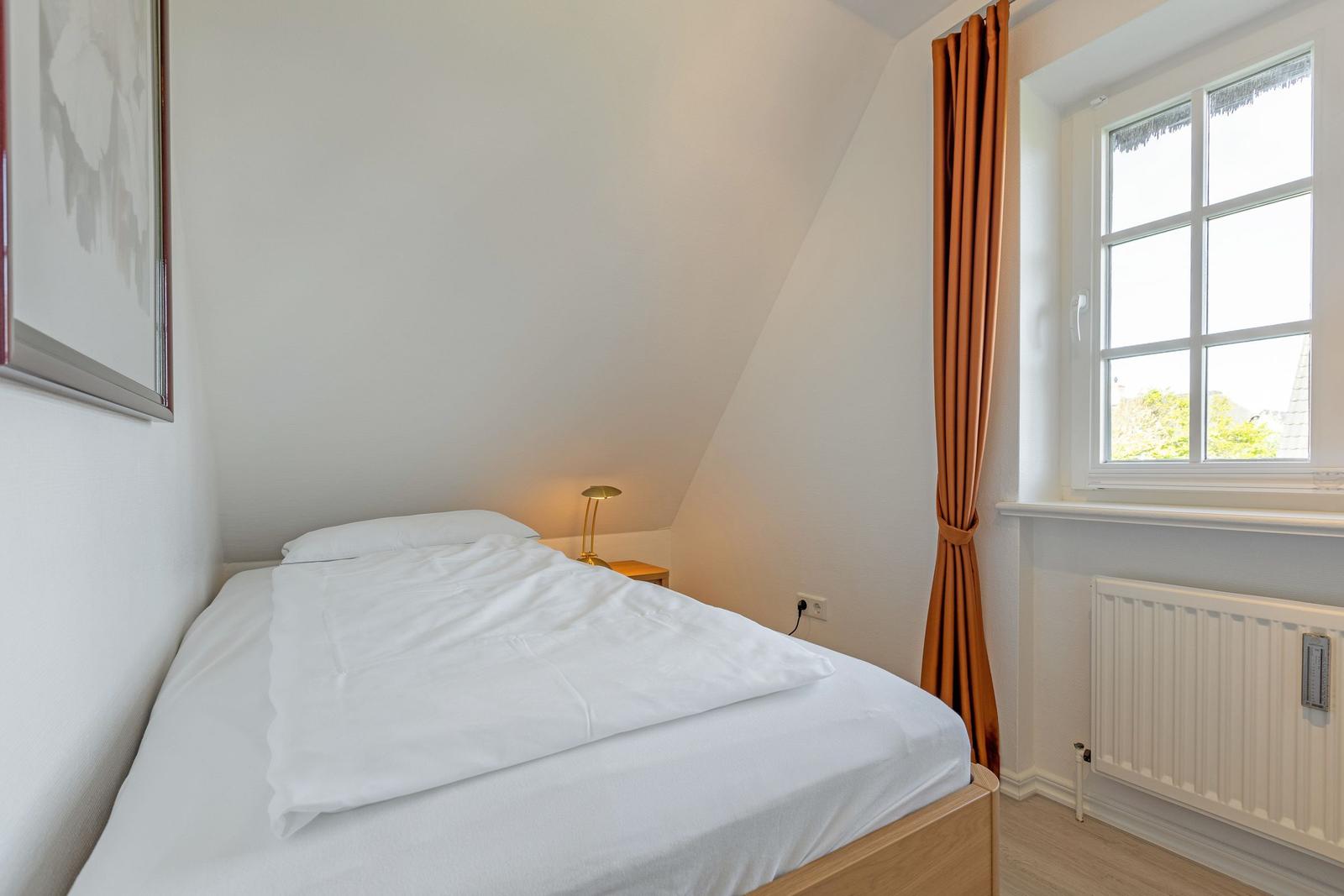 Bedroom with double bed, window, and radiator.