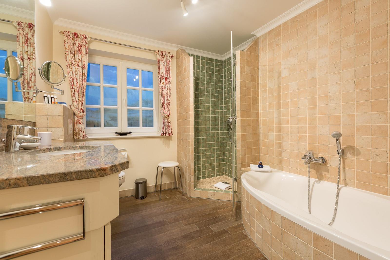 Bathroom with shower, bathtub, and window with curtains.