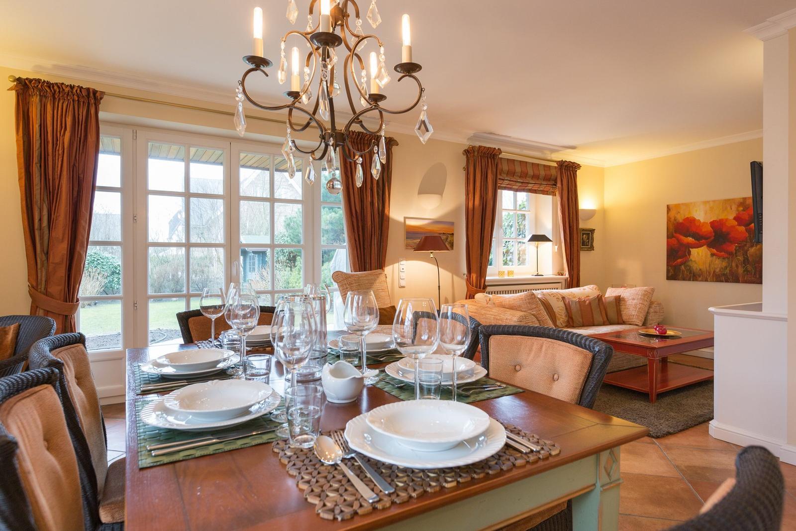 Dining table for six, living area with sofa and chandelier.