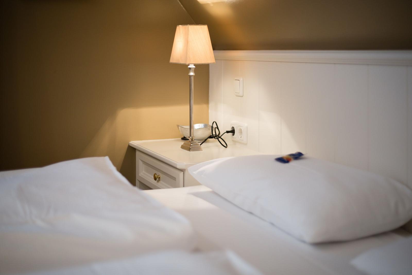 Bedroom with bed, nightstand, and lamp.