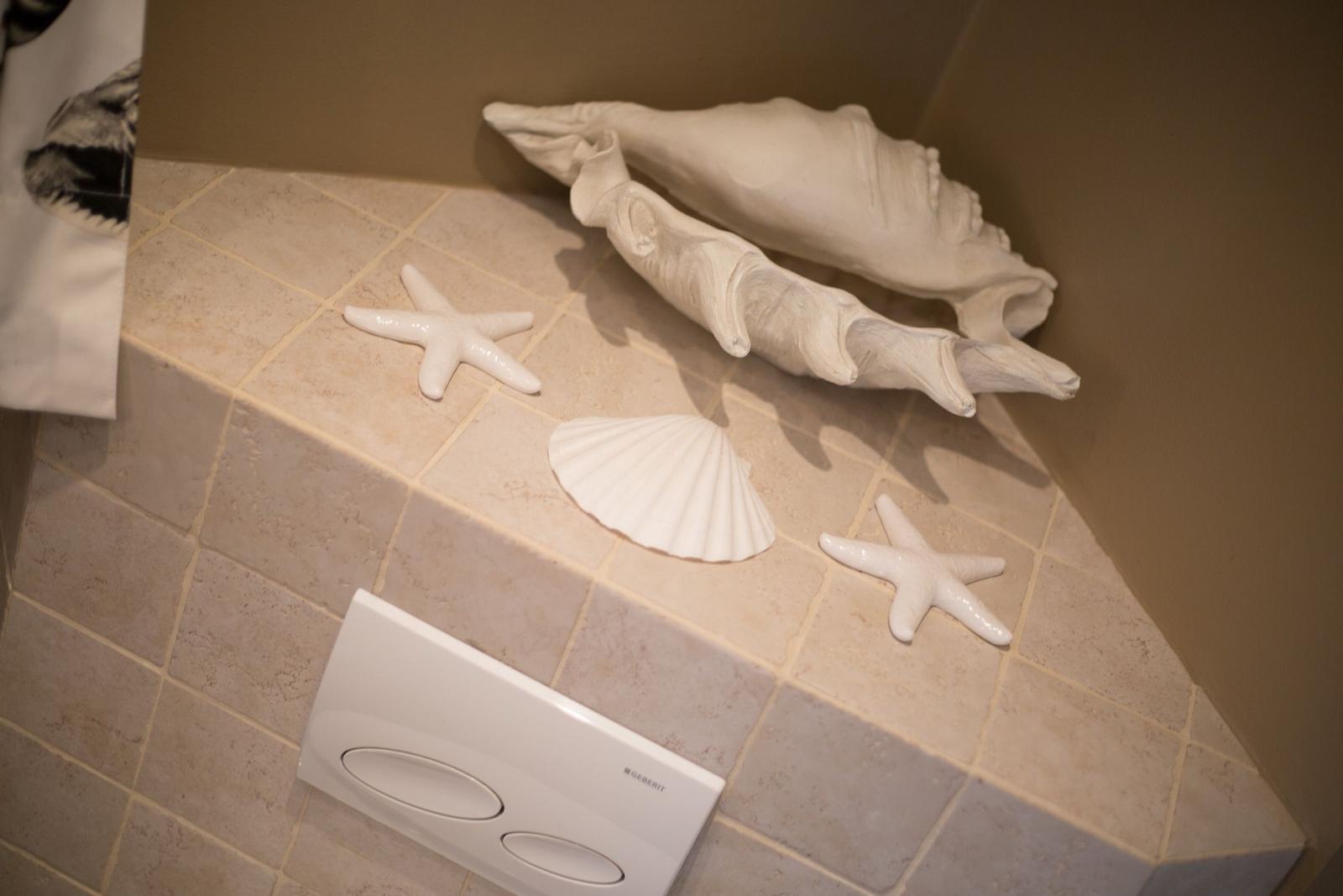 Bathroom area with white shells and starfish on tiles