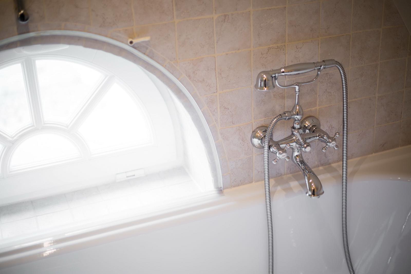 Bathtub with shower head and bathroom window
