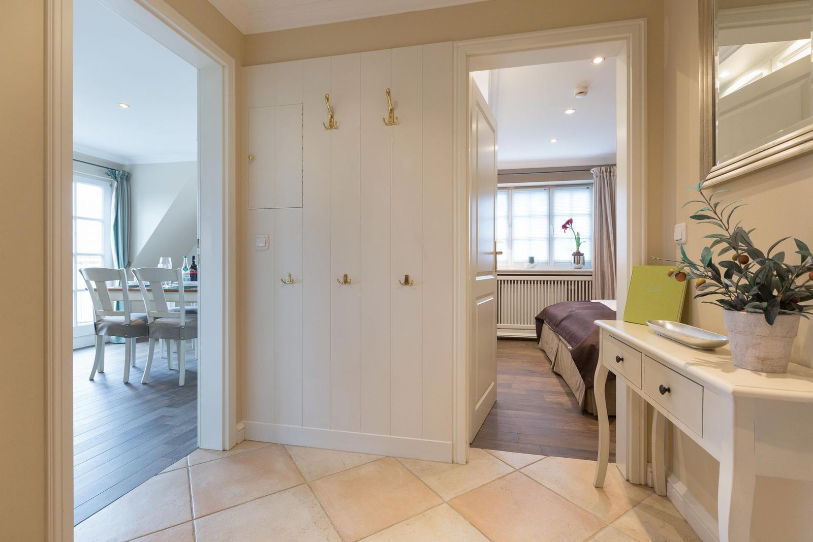 Entrance with wardrobe, view into bedroom and dining room.