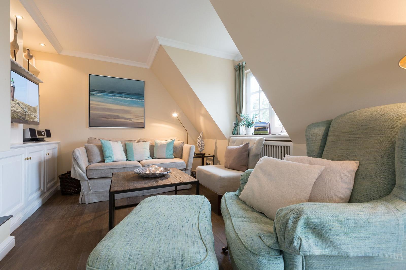 Living room with sofa, armchair, and TV mounted on the wall