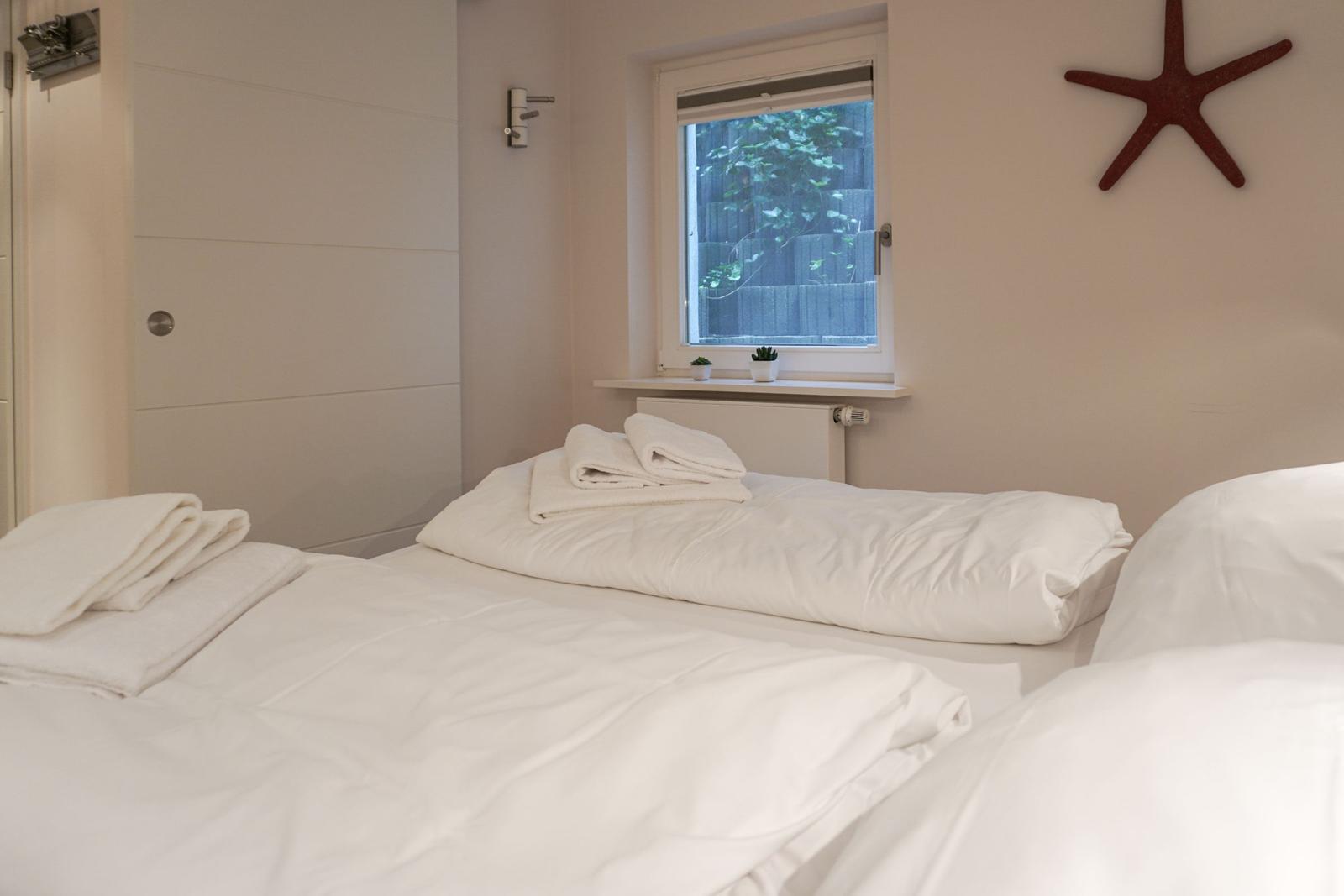 Schlafzimmer mit Bett, Fenster und Wanddekoration