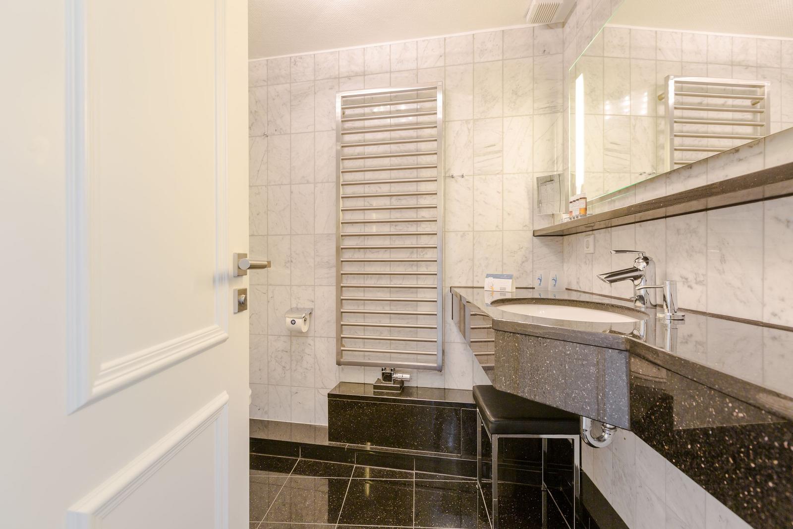 Bathroom with sink, mirror, and heater on wall