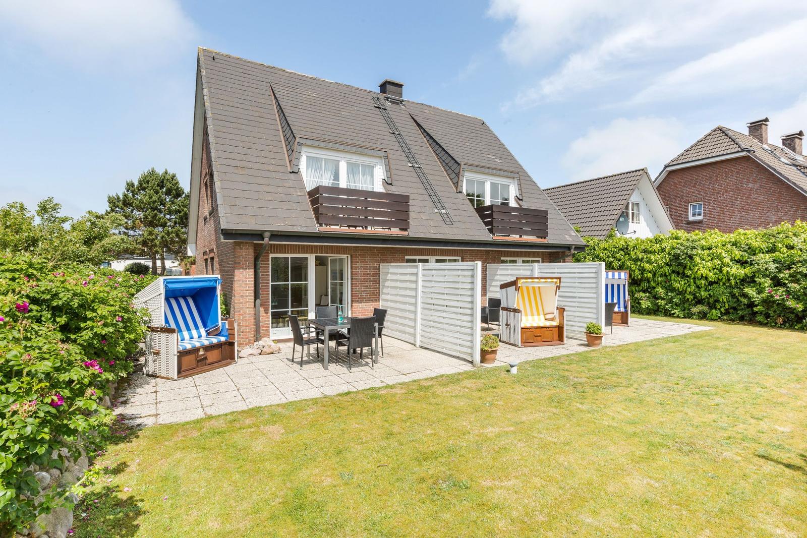 House with terrace, garden and beach chairs.