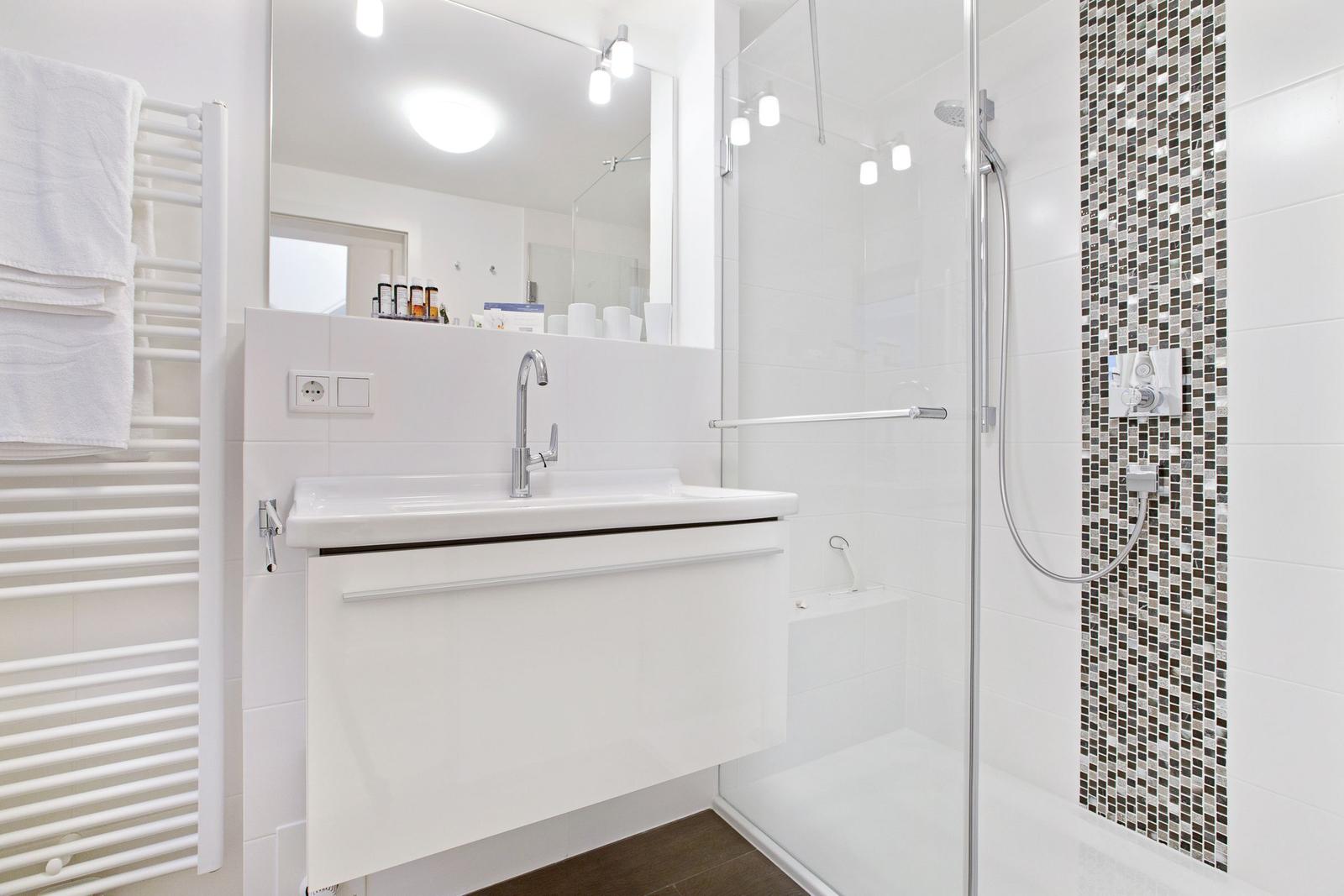 Bad mit Dusche, Waschbecken und Handtuchheizkörper