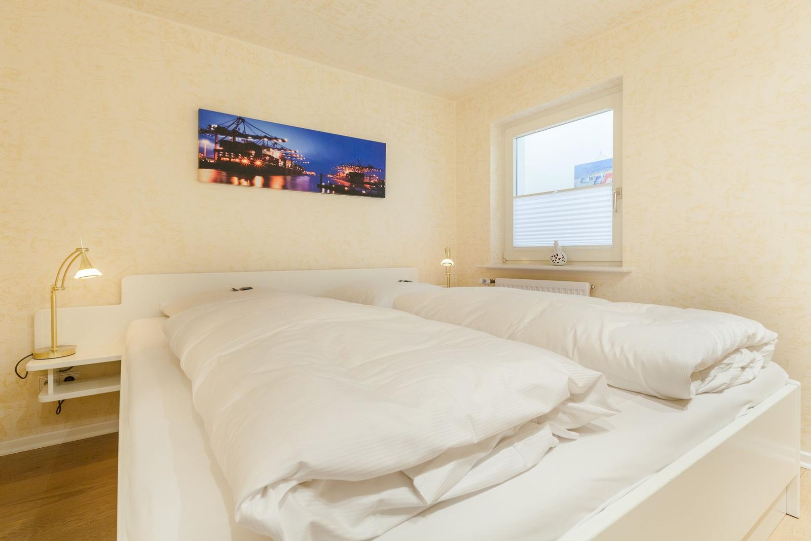 Schlafzimmer mit Doppelbett, Wandbild und Fenster