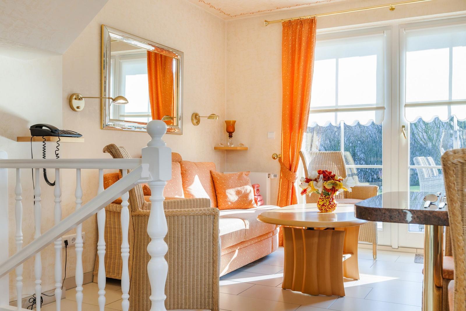 Wohnzimmer mit Sofa, Tisch und Blick auf Balkon.