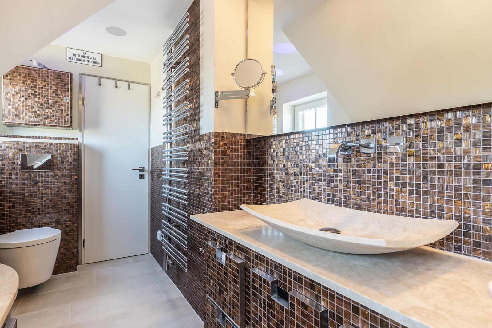 Bad mit Mosaikwand, Waschtisch und Toilette