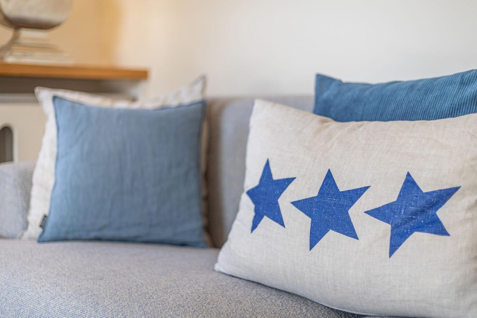 Sofa mit Kissen, eines mit drei blauen Sternen.