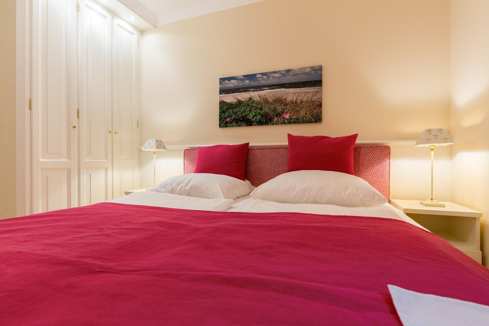 Bedroom with bed, nightstands, and wall art.