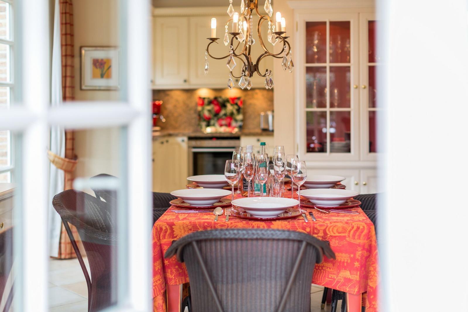 Dining table with tablecloth and glasses in dining area