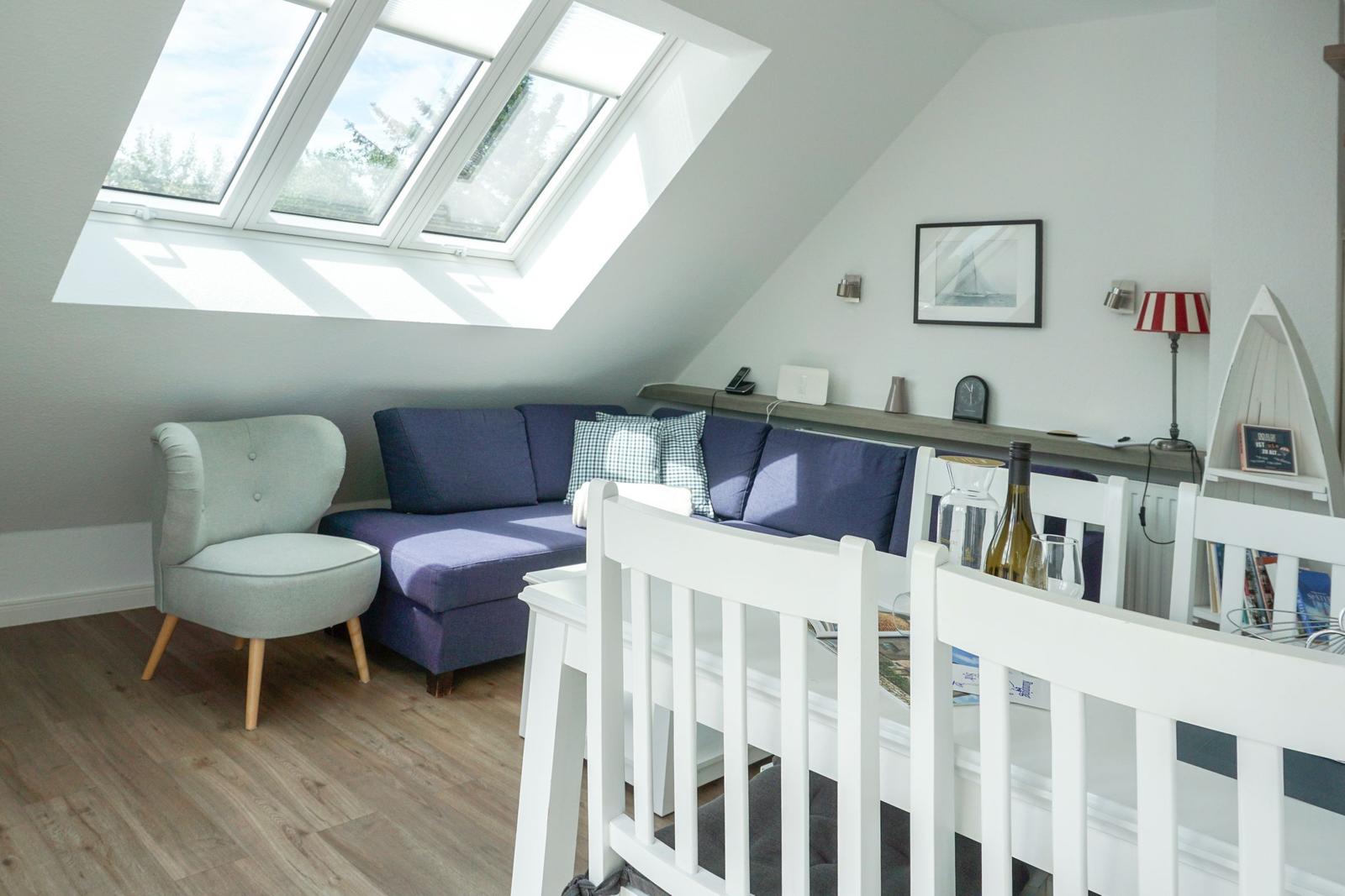 Living space with sloped ceiling, skylight, sofa and chair
