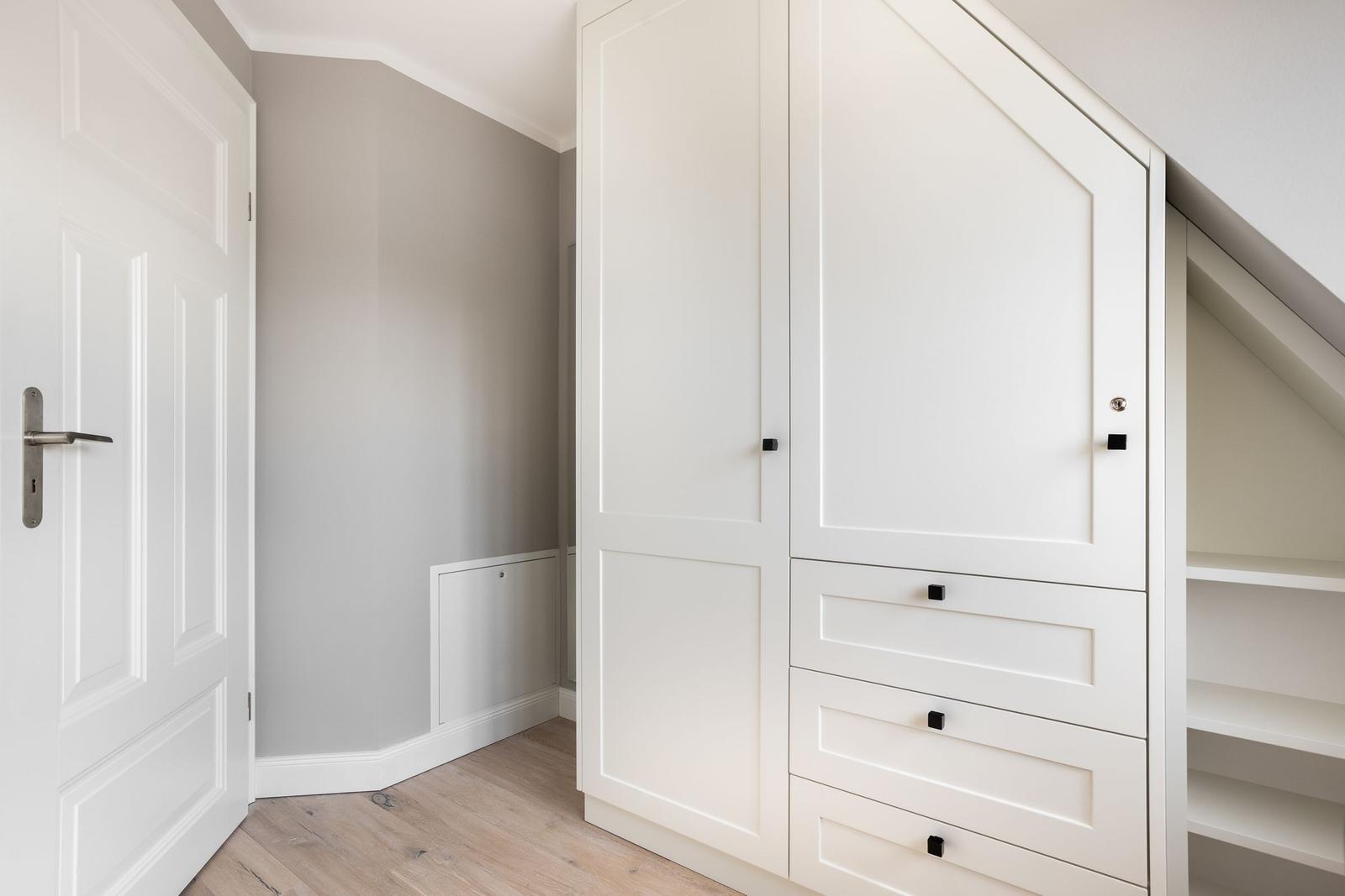Schlafzimmer mit weißem Schrank und Holzboden