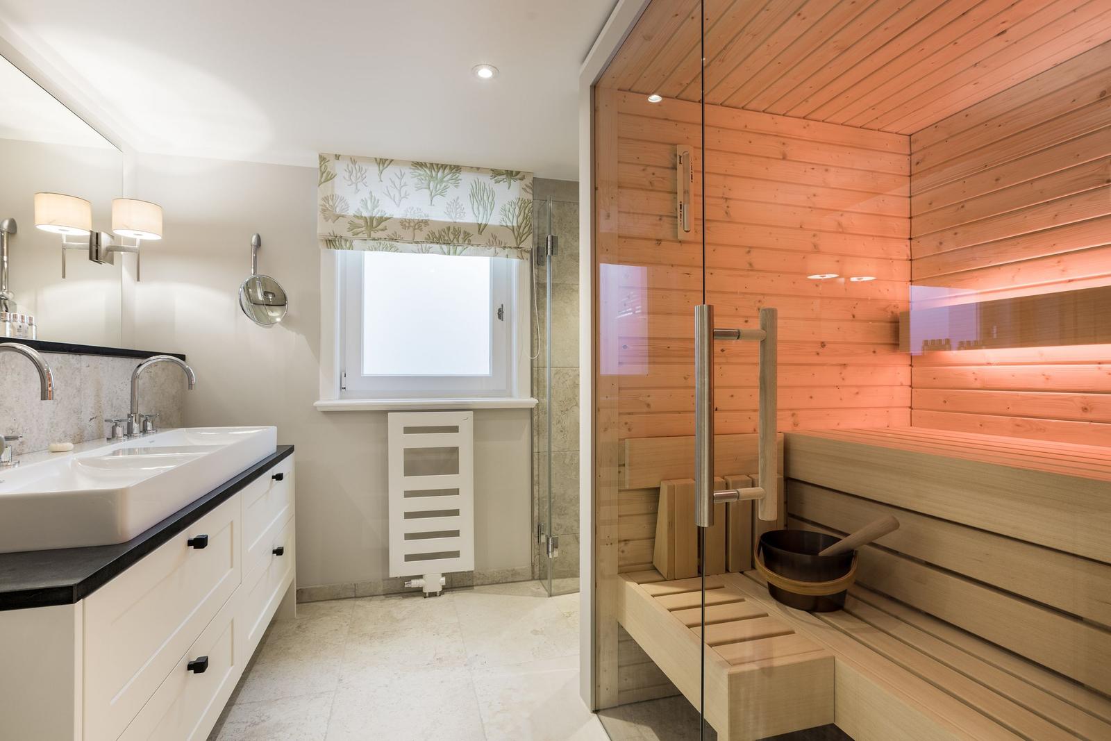 Badezimmer mit Sauna, Waschbecken und Fenster